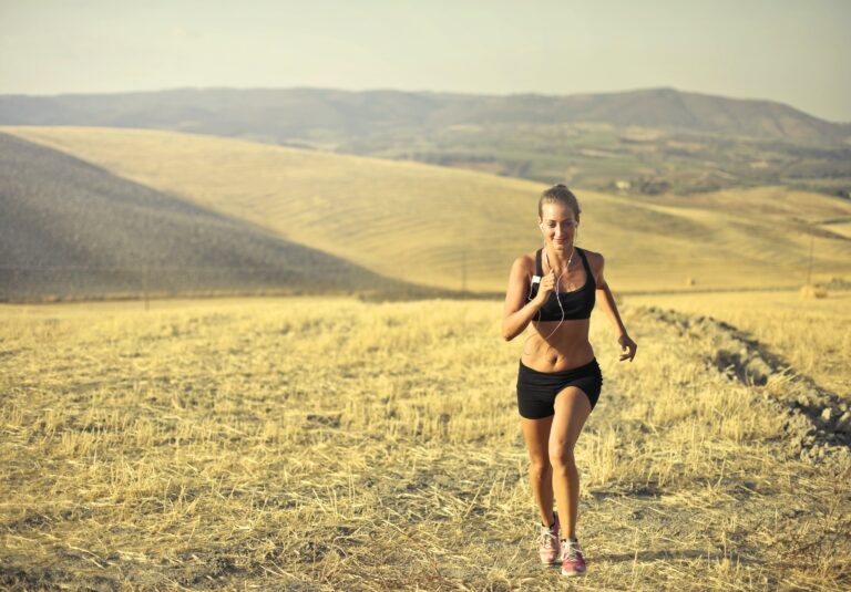 Healthy woman running on open landscape