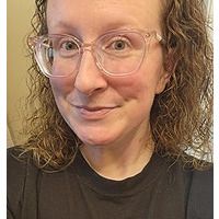 Smiling woman with glasses and curly hair